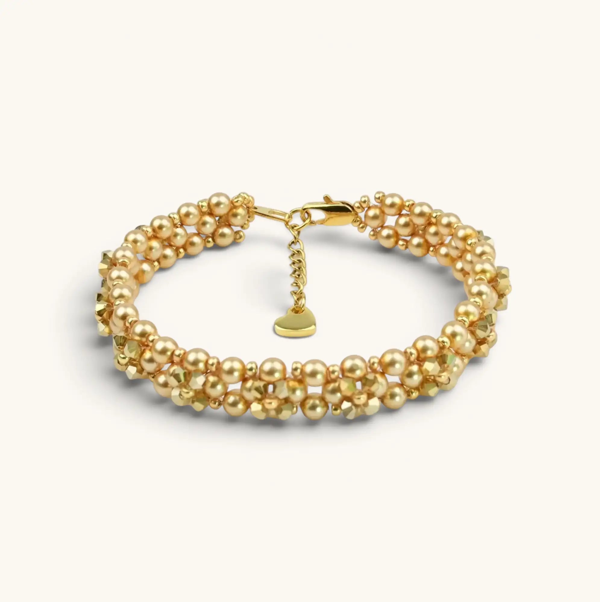 Vergoldetes mehrreihiges Armband mit einer Kombination aus runden Perlen und facettierten Perlen, mit einem kleinen herzförmigen Anhänger als Akzent.